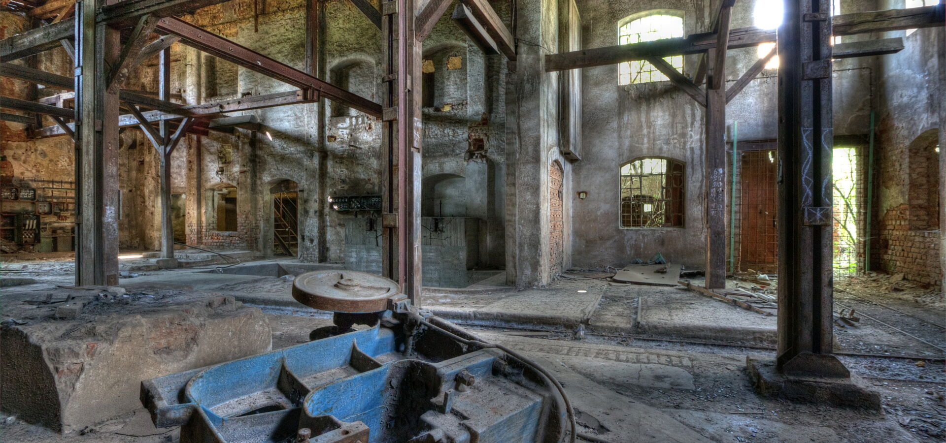 Alte Fabrikhalle mit Rost, Holz und zerfallenden Wauern.