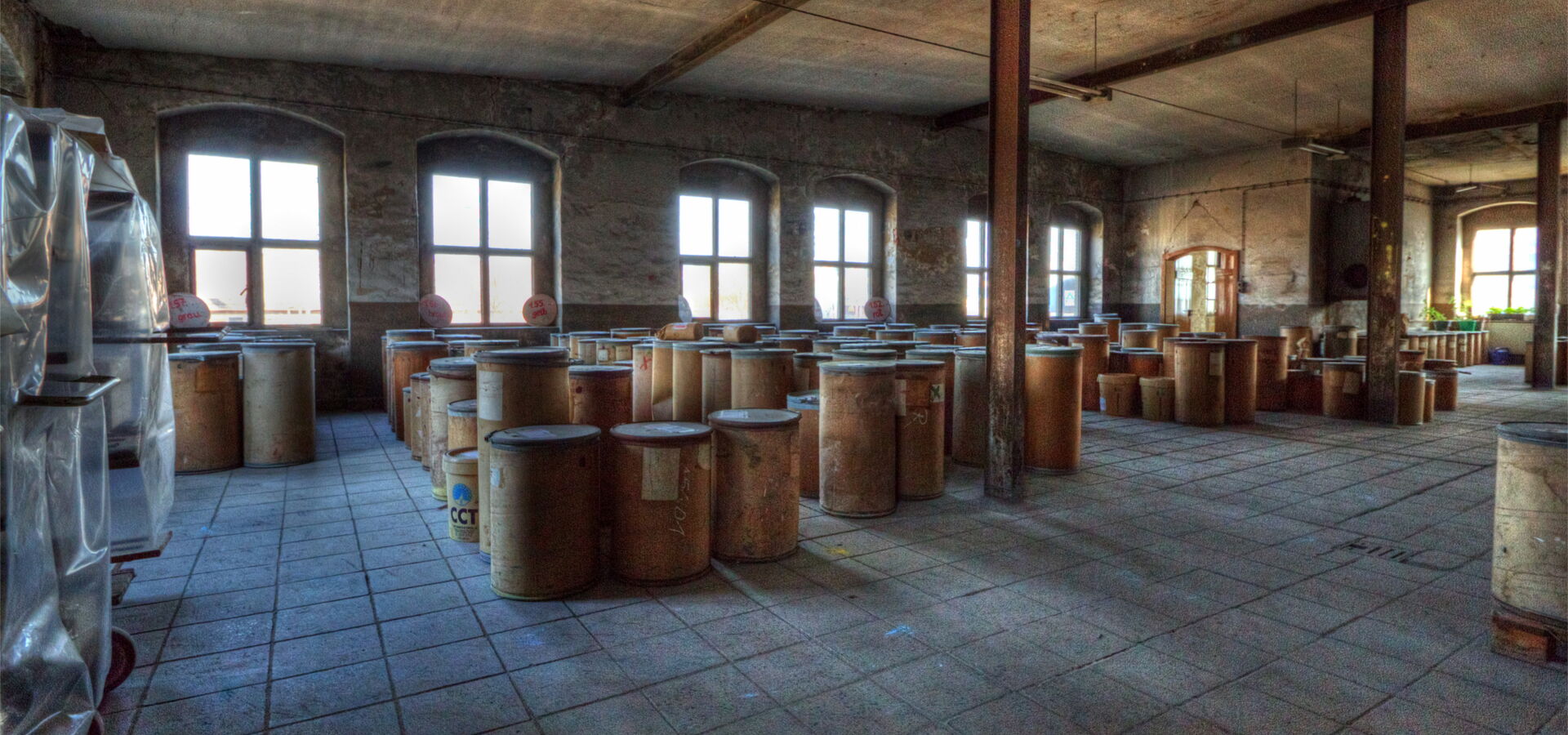 Lagerraum mit vielen Holzfässern und Fenstern.